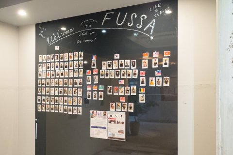 A wall of resident photos and country flags at an Oakhouse property